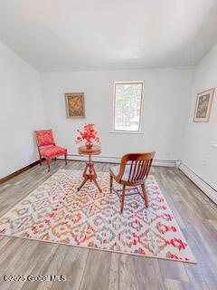 living area with baseboards and wood finished floors