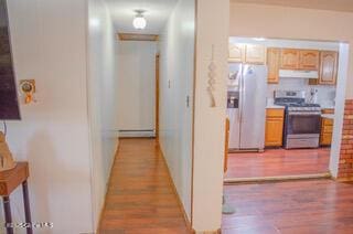 corridor with baseboards, wood finished floors, and baseboard heating