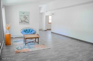 living area with baseboards and wood finished floors