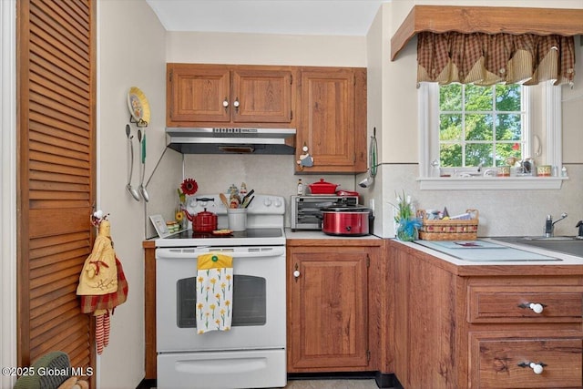 5 Hillview Ave, East Greenbush, NY 12144 - kitchen featuring electric range, under cabinet range hood, light countertops, and brown cabinetry