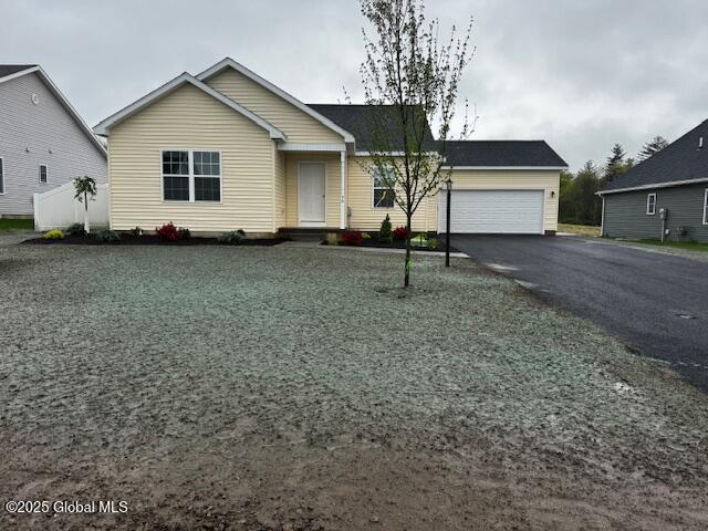 ranch-style home featuring a garage and aphalt driveway