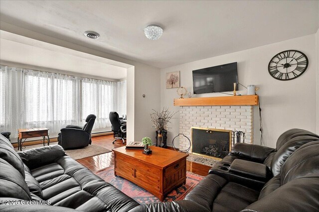 1576 State St, Schenectady, NY 12304 - living area featuring a brick fireplace, wood finished floors, and baseboard heating