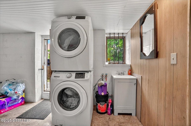 1576 State St, Schenectady, NY 12304 - laundry room with stacked washing machine and dryer, concrete block wall, and wood walls