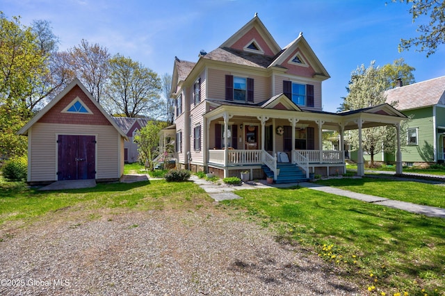 victorian home featuring covered porch, a front lawn, and an outdoor structure