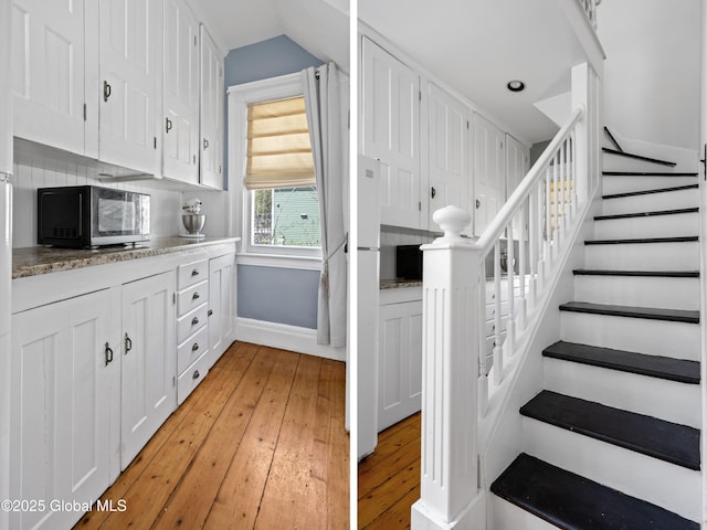 stairs with baseboards, wood-type flooring, vaulted ceiling, and recessed lighting