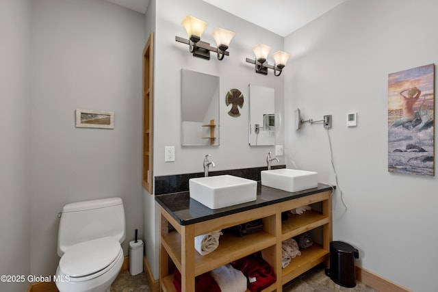 bathroom featuring toilet and double vanity