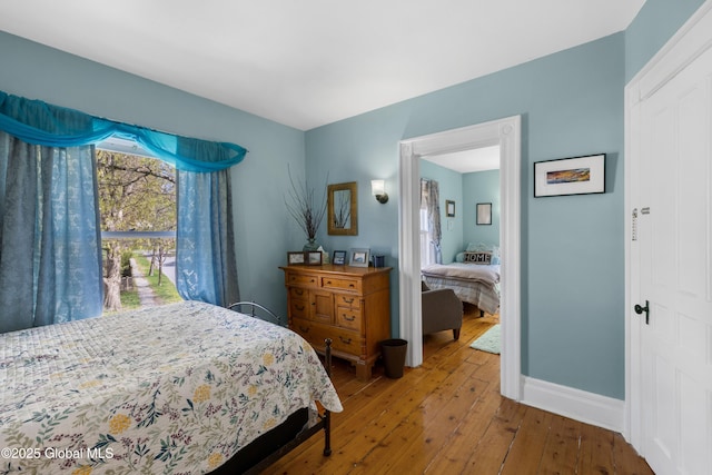 bedroom with wood-type flooring and baseboards