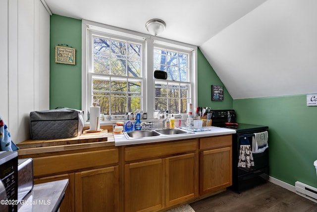 kitchen with black range with electric stovetop, a sink, a baseboard radiator, vaulted ceiling, and dark wood-style flooring