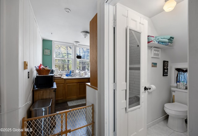 bathroom with toilet, vanity, and tile patterned flooring