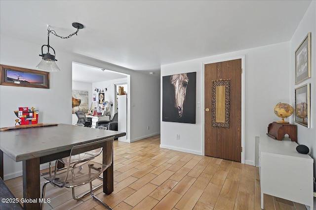 dining area with light wood finished floors and baseboards