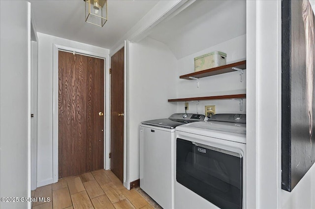 clothes washing area featuring separate washer and dryer and light wood finished floors