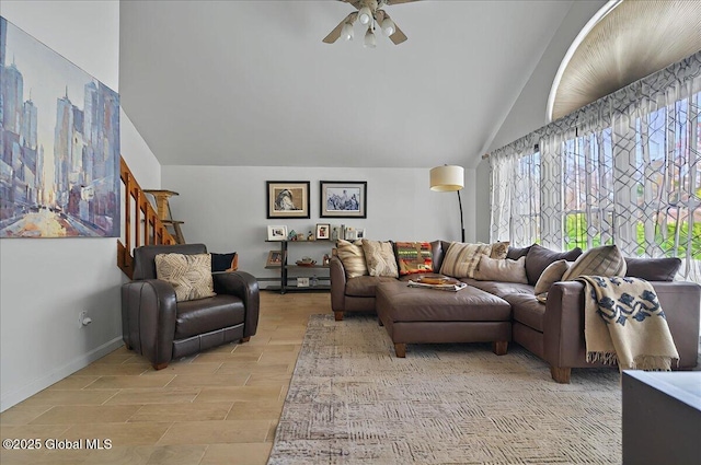 living area with vaulted ceiling, a ceiling fan, and baseboards
