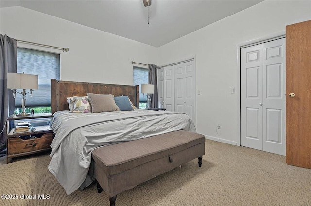 carpeted bedroom featuring two closets and multiple windows