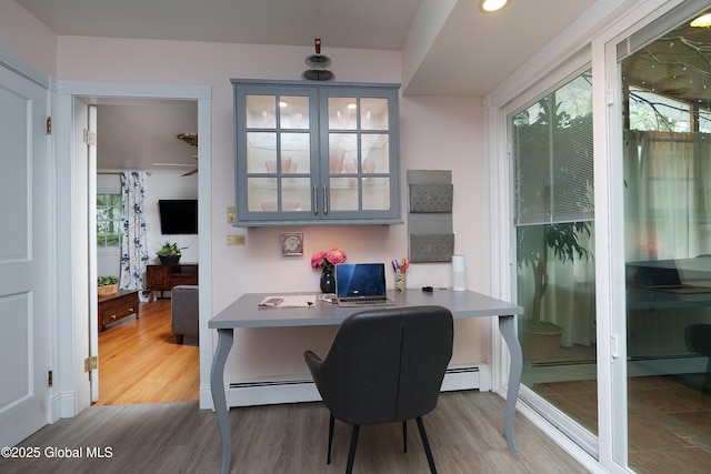 office space with wood finished floors and baseboard heating