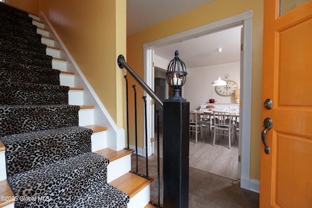stairs with crown molding and tile patterned flooring