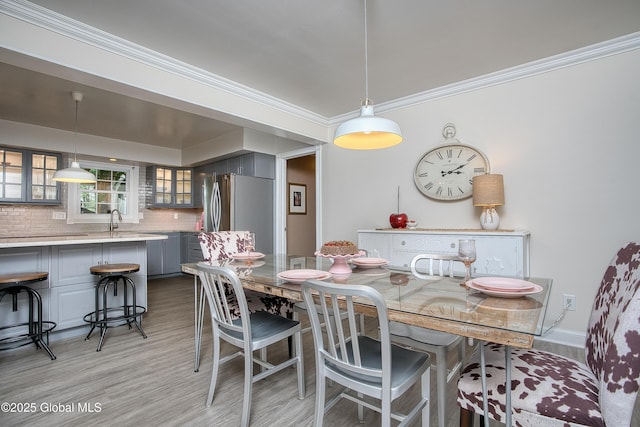 dining area featuring crown molding and light wood-type flooring