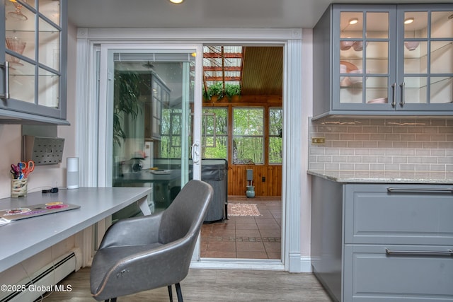 home office featuring a baseboard heating unit and wood finished floors