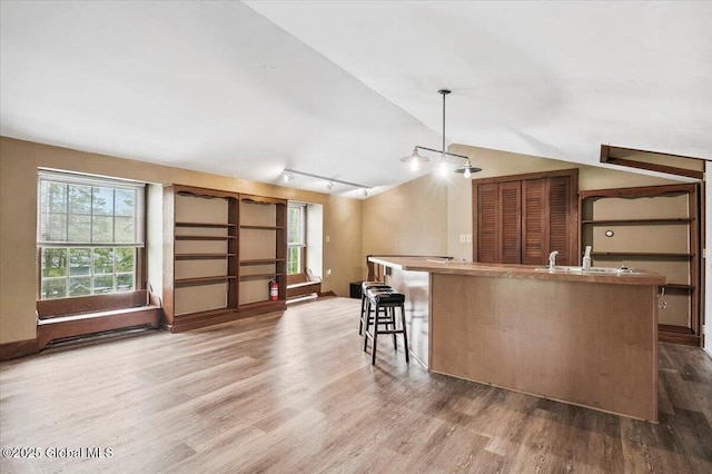 11 Cotton Ct, Bolton, NY 12824 - kitchen with wood finished floors, vaulted ceiling, a center island with sink, decorative light fixtures, and a sink