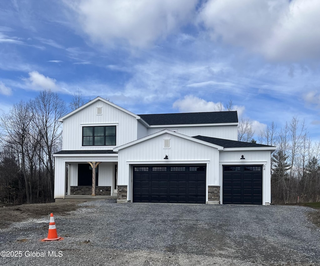modern inspired farmhouse featuring a garage, stone siding, asphalt driveway, a porch, and a shingled roof