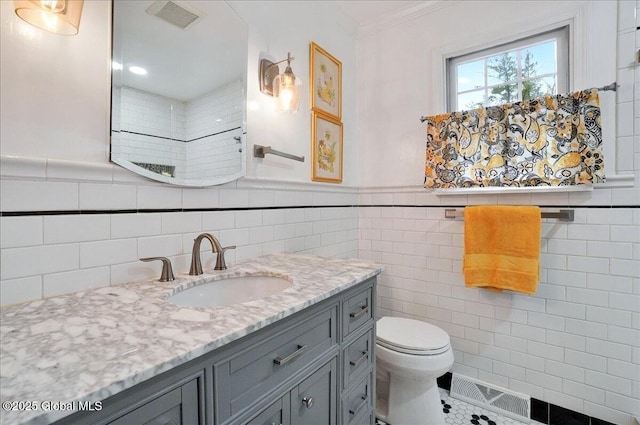 full bath with tile walls, toilet, and visible vents