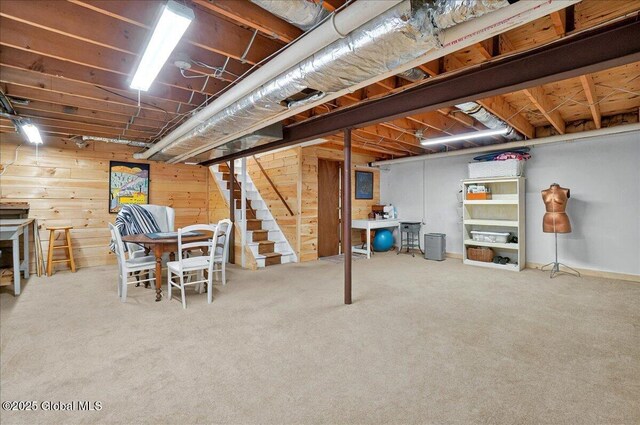 unfinished below grade area with carpet flooring, stairway, and wooden walls