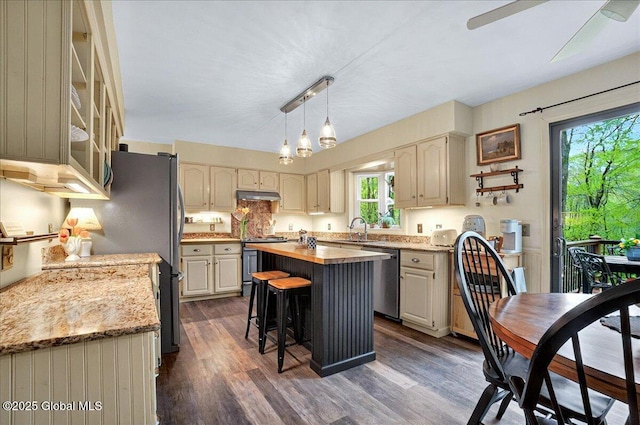 kitchen with a center island, range, under cabinet range hood, dishwasher, and butcher block counters