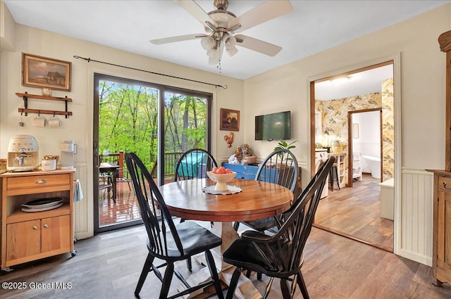dining space with a ceiling fan and light wood-style flooring