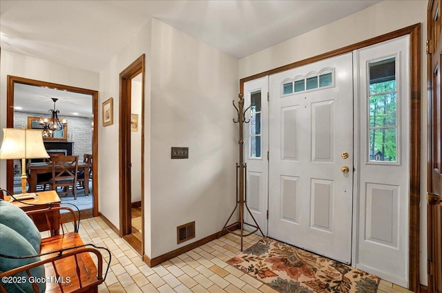 foyer entrance with an inviting chandelier and baseboards