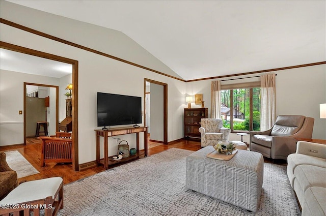 living area with lofted ceiling, baseboards, and wood finished floors
