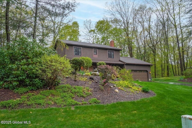 view of front facade featuring a chimney, a front lawn, and a garage