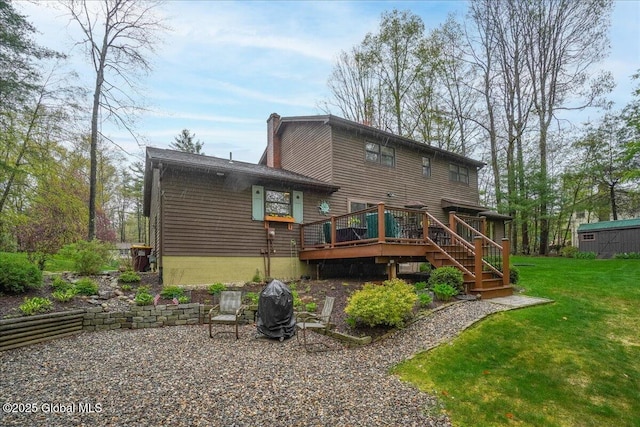back of house featuring a yard, a wooden deck, and stairs