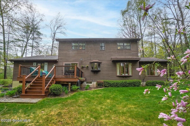 back of house with stairway, a deck, and a lawn
