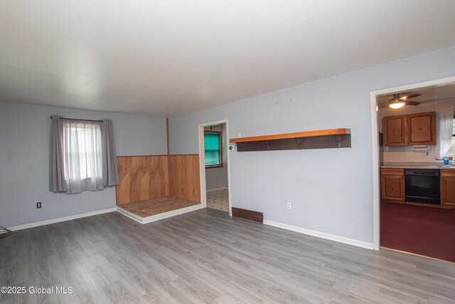 empty room with wood finished floors, healthy amount of natural light, and baseboards