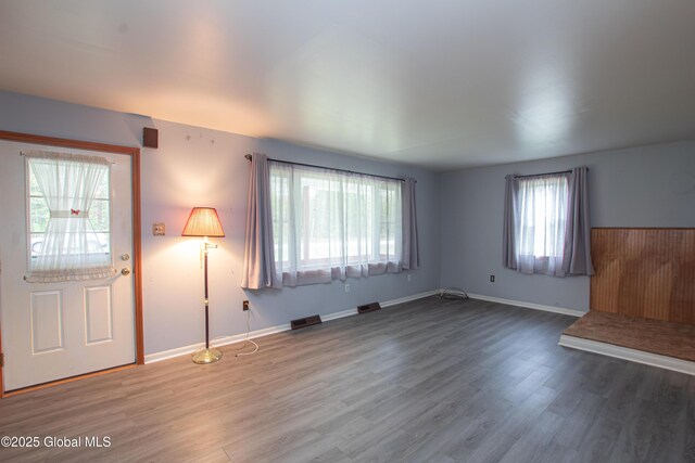 unfurnished living room featuring wood finished floors and baseboards