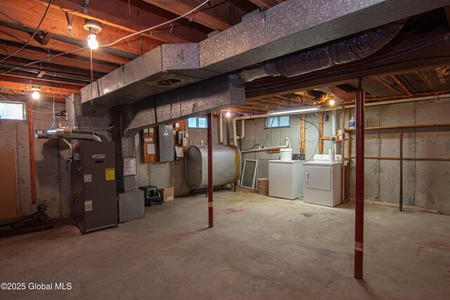 basement with washing machine and clothes dryer, heating fuel, heating unit, and electric panel