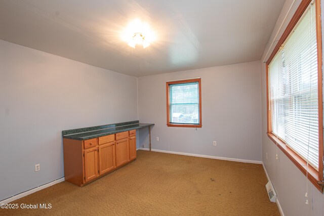 spare room with light colored carpet and baseboards