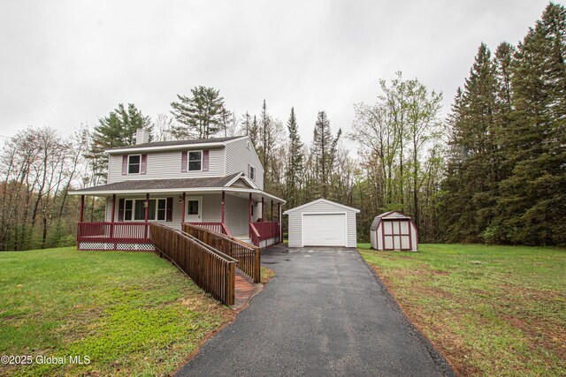 view of front of house featuring covered porch, an outdoor structure, driveway, a storage unit, and a chimney