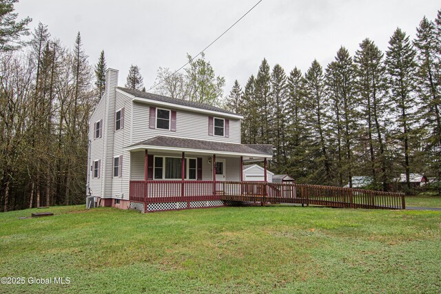 view of front of property featuring a chimney, a porch, and a front yard