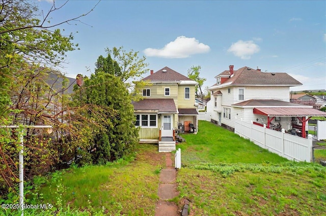 rear view of property with a lawn