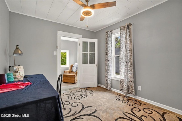 dining room featuring a ceiling fan, crown molding, and baseboards