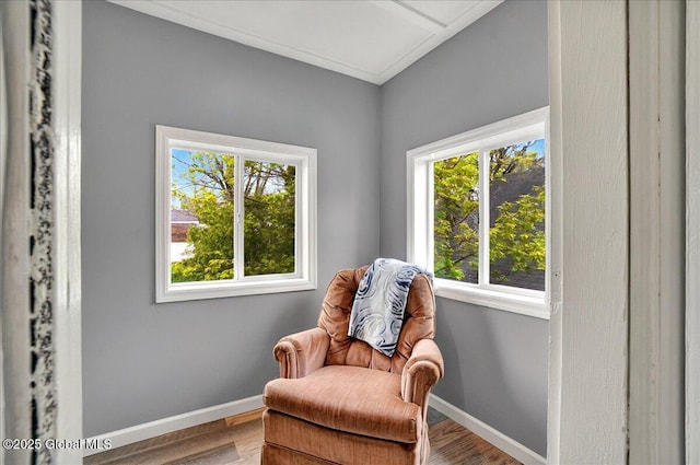 living area with baseboards and wood finished floors