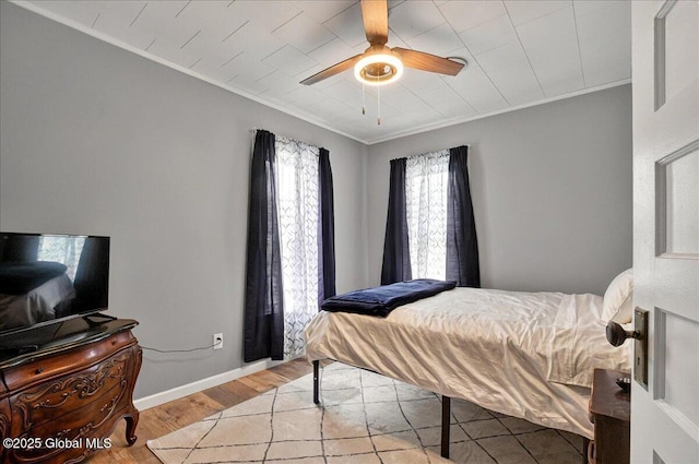 bedroom featuring crown molding, light wood-style floors, ceiling fan, and baseboards