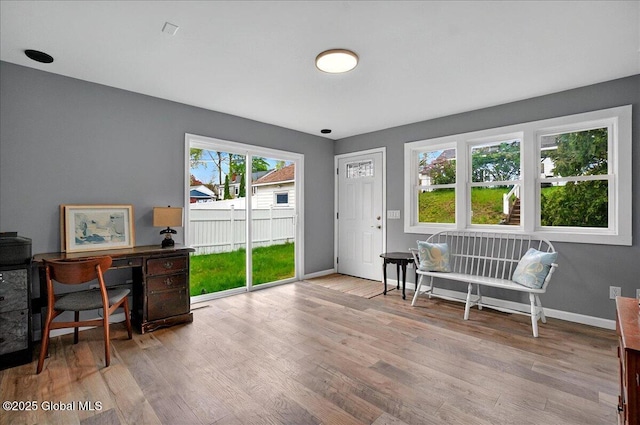 sitting room featuring wood finished floors, baseboards, and an office area