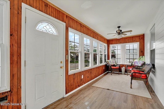 sunroom featuring wood walls and wood finished floors