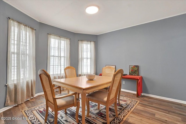 dining area featuring ornamental molding, wood finished floors, and baseboards