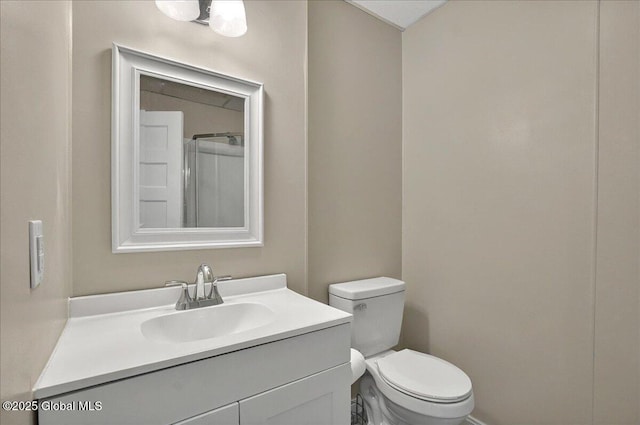 bathroom featuring vanity, toilet, baseboards, and a shower