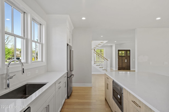 kitchen with a sink, plenty of natural light, recessed lighting, stainless steel appliances, and light wood-type flooring