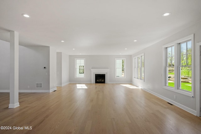 unfurnished living room featuring baseboards, light wood-style flooring, recessed lighting, and a fireplace