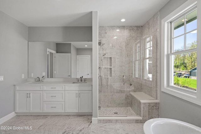 full bathroom featuring a marble finish shower, a freestanding bath, double vanity, baseboards, and recessed lighting