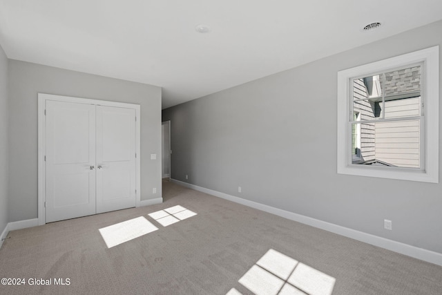 unfurnished bedroom with carpet, baseboards, and a closet